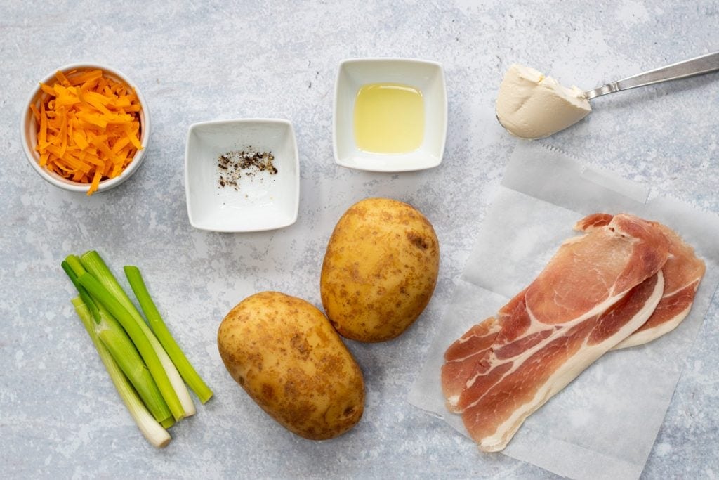 Ingredients for stuffed potato skins: Baking potatoes, bacon, cheese, cream cheese, spring onions, oil, salt and pepper
