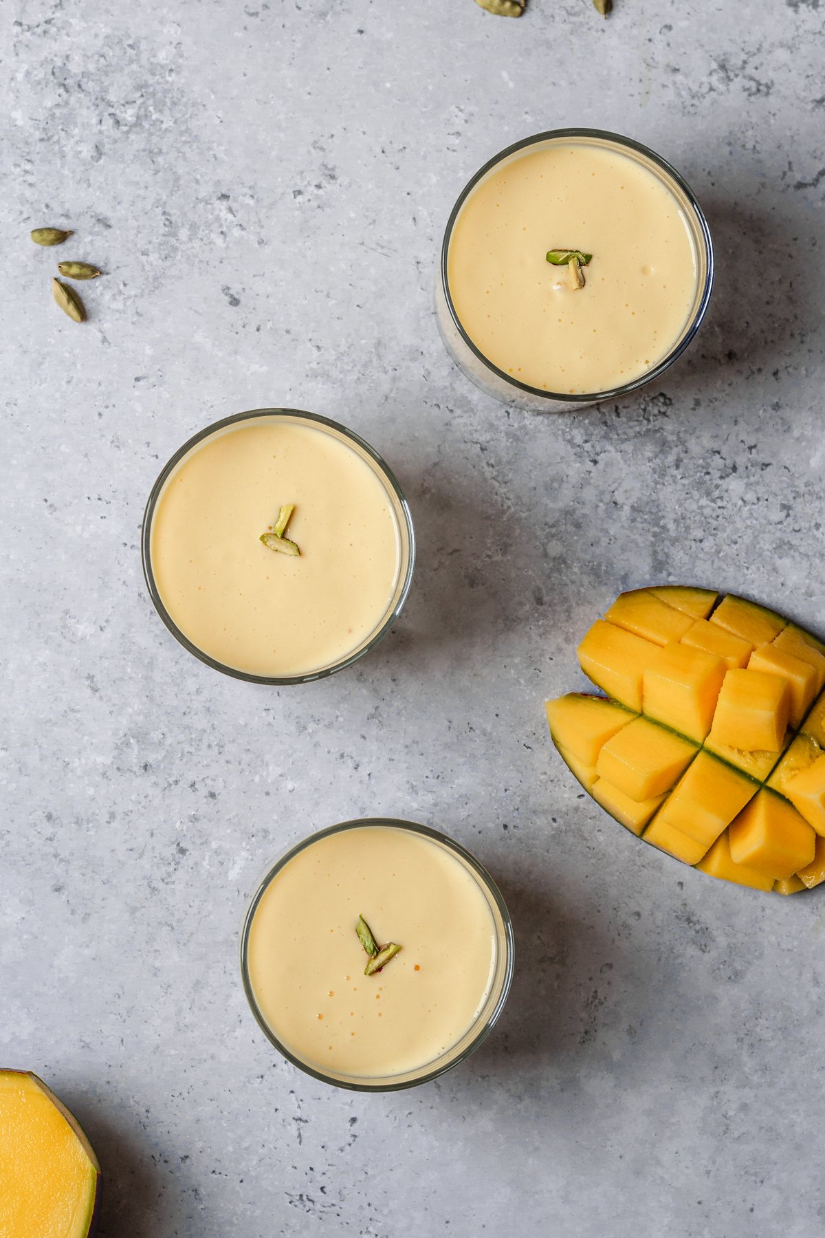 flatlay of 3 glasses of mango lassi